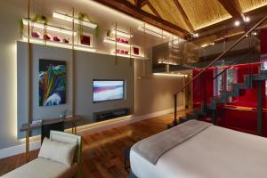 a bedroom with a bed and a tv and stairs at Casa Firenza Hotel & Suites Boutique in Cuenca +52 photos