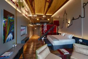 a hotel room with a bed and a couch at Casa Firenza Hotel & Suites Boutique in Cuenca
