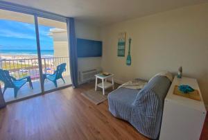 a living room with a bed and a balcony at Sea Dip Resort Studios! in Daytona Beach