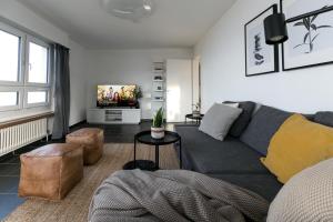 ein Wohnzimmer mit einem Sofa und einem TV in der Unterkunft Inn Joy Apartments Rorschach mit Panoramasicht in Rorschach