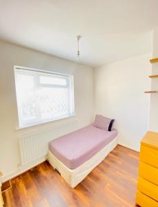 een slaapkamer met een bed in een kamer met een raam bij Cozy & Quiet Two Bedroom Apartment in Chingford