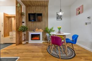 a living room with a table and chairs and a fireplace at SkyLine Lux Apartman Zlatna Lisica Zlatibor in Zlatibor