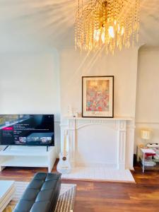 a living room with a fireplace and a chandelier at Cozy & Quiet Two Bedroom Apartment in Chingford