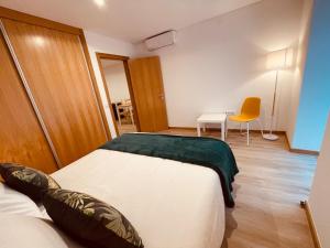 um quarto com uma cama, uma mesa e uma cadeira em Living Funchal X em Funchal