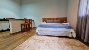 a bedroom with a large bed and a rug at Boulevard Montreal in Monte Verde