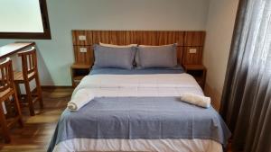 a bedroom with a large bed with blue and white sheets at Boulevard Montreal in Monte Verde