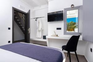 a bedroom with a bed and a chair and a window at Filoxenia Luxury Villas in Perissa