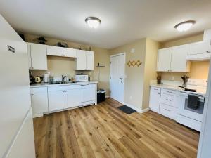 a kitchen with white cabinets and a wooden floor at Far East Escape- Salem in Salem
