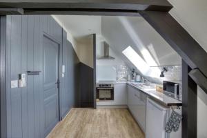 una cocina con armarios blancos y una puerta azul en Tout simplement: confort !, en Bourges