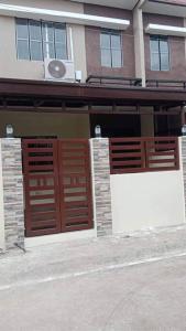 ein Gebäude mit zwei Holztüren und einem Gebäude in der Unterkunft 2 Bedroom townhouse in Bacolod City in Bacolod City