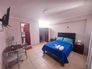 Schlafzimmer mit einem blauen Bett und einem Schreibtisch in der Unterkunft Residencia Benavides in San Vicente de Cañete
