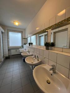 a bathroom with four sinks and a row of mirrors at Black Sheep in Cologne +57 photos