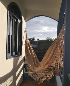una hamaca colgada de una ventana en un balcón en Casa Miosótis apartamentos, en Palhoça