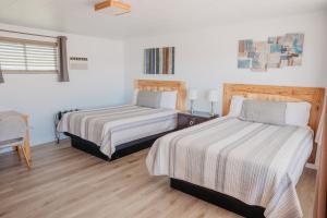 1 dormitorio con 2 camas, mesa y escritorio en Lamplighter Lodge, en Panguitch