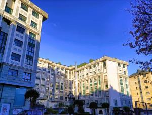 twee hoge gebouwen in een stad met een blauwe lucht bij LA ERIA II, muy luminoso,WIFI, garaje,15 a pie al centro in Oviedo