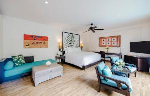 une chambre d'hôtel avec un lit et un canapé dans l'établissement Anantara Mai Khao Phuket Villas, à Mai Khao Beach