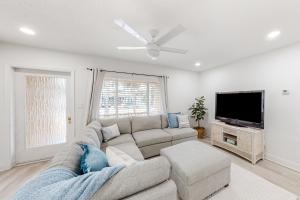 a living room with a couch and a flat screen tv at Paradise Found in Clearwater Beach