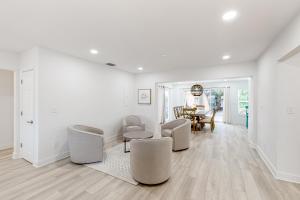 a white living room with chairs and a table at Paradise Found in Clearwater Beach