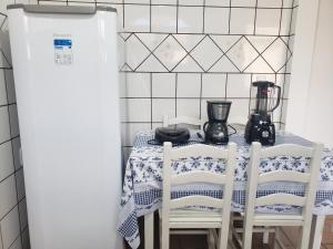 cocina con mesa con sillas y licuadora en Casa Miosótis apartamentos, en Palhoça