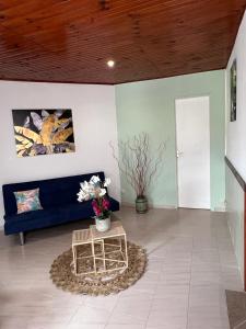 ein Wohnzimmer mit einem blauen Sofa und einem Tisch in der Unterkunft Poseidon in Le Lamentin