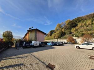 um parque de estacionamento com carros estacionados ao lado de uma montanha em Residenza La Cascata em Calolziocorte