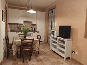 a kitchen and dining room with a table and a television at Residenza La Cascata in Calolziocorte