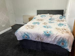 uma cama com um edredão azul e branco em Large family house in Clitheroe em Clitheroe