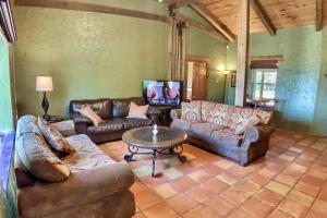 sala de estar con sofás de cuero y mesa en Stone Wall Mountain, en Eureka Springs