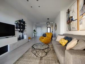 a living room with a couch and a tv at SUNSET WAVES superb apartments in Benidorm