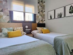 a bedroom with two beds and a window at SUNSET WAVES superb apartments in Benidorm +34 photos