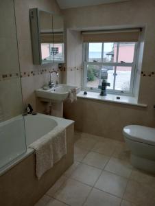 a bathroom with a tub and a sink and a toilet at Quayside in Porthscatho