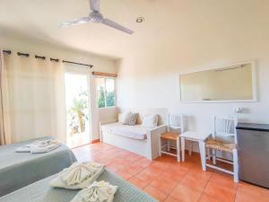 a room with two beds and a couch and a mirror at Olas de Cerritos in El Pescadero