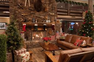 a living room with christmas trees and a fireplace at The Grand Hotel at the Grand Canyon in Tusayan