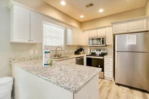 a kitchen with white cabinets and a stainless steel refrigerator at Fairway Oaks Getaway in Myrtle Beach