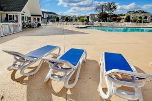 two blue and white chairs sitting next to a swimming pool at Fairway Oaks Getaway in Myrtle Beach