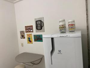 een kleine witte koelkast met twee kopjes erop bij Posto 9, Ipanema 2 quartos com suíte in Rio de Janeiro