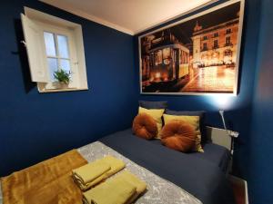 een blauwe kamer met een bed met een foto aan de muur bij Sto Antonio Guest House in Lissabon