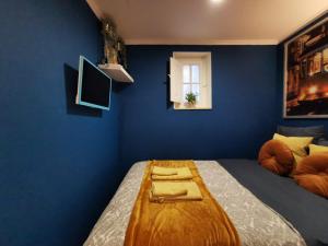 een blauwe slaapkamer met een bed en een houten tafel bij Sto Antonio Guest House in Lissabon