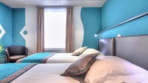 Letto o letti in una camera di Hotel Le Terminus