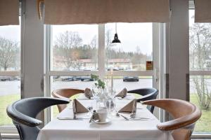 een eetkamer met een tafel, stoelen en ramen bij Best Western Hotel Vrigstad in Vrigstad