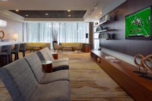 a living room with two couches and a flat screen tv at Sonesta Select Atlanta Cumberland Galleria in Atlanta