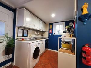 a kitchen with a washing machine and a blue wall at Studio Sto Antonio Alfama in Lisbon +11 photos