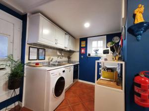 リスボンにあるSto Antonio Guest Houseの青い壁のキッチン(洗濯機付)