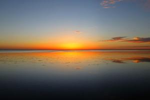 einen Sonnenuntergang am Strand mit dem Meer in der Unterkunft DAR OOMI in Zarzis