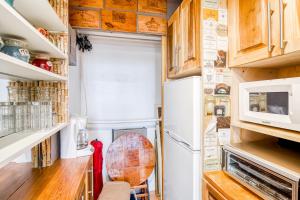 a tiny kitchen with a refrigerator and a fan at Palm Rising in Palm Beach