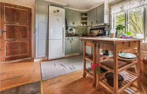 a kitchen with green cabinets and a white refrigerator at 2 Bedroom Stunning Home In Aneby in Aneby