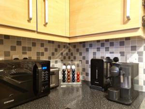 a kitchen counter with a coffee maker and a microwave at The Belmont, Old Town in Swindon +18 photos