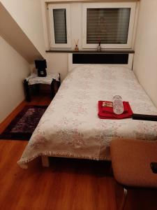 Un dormitorio con una cama con una servilleta roja. en Chambre Privé dans belle maison 1, en Ettelbruck