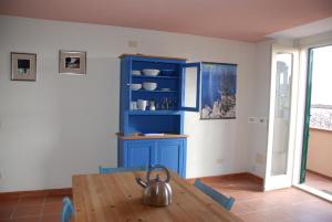 a kitchen with a table and a blue cabinet at Al Vecchio Convento in Orosei
