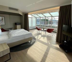 a bedroom with a bed and a table and chairs at Crowne Plaza Hamburg-City Alster, an IHG Hotel in Hamburg